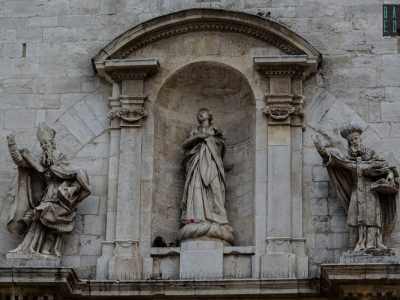 ...la cui linearit� romanica � spezzata da un gruppo di statue barocche che rappresentano la Madonna affiancata da due figure dalla lunga barba